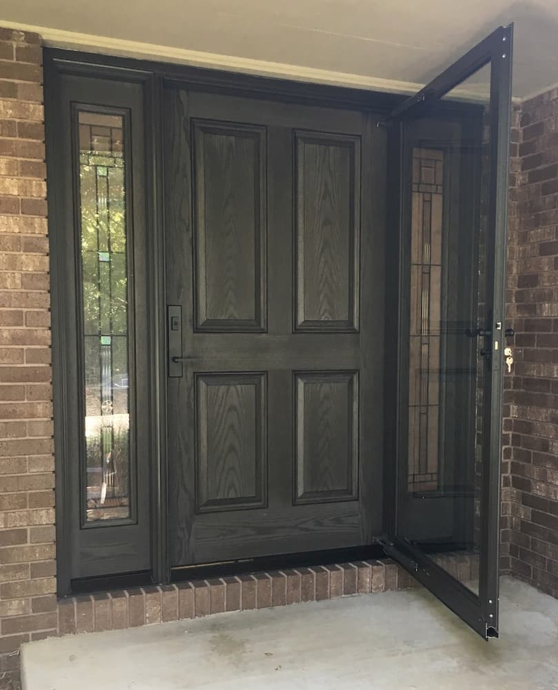 New dark wood-grain fiberglass entry door system with two full-length sidelights and a storm door