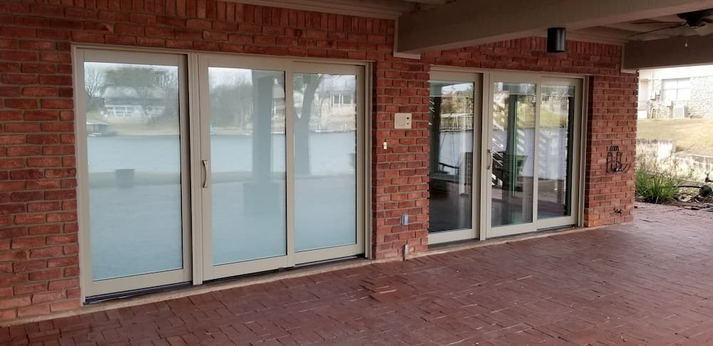 Two clad wood sliding doors on a brick home