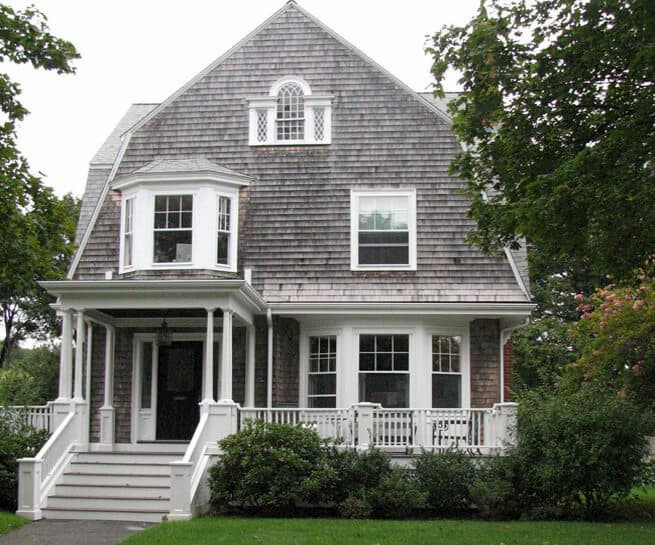 Front exterior view of shingle-style home with old wood window