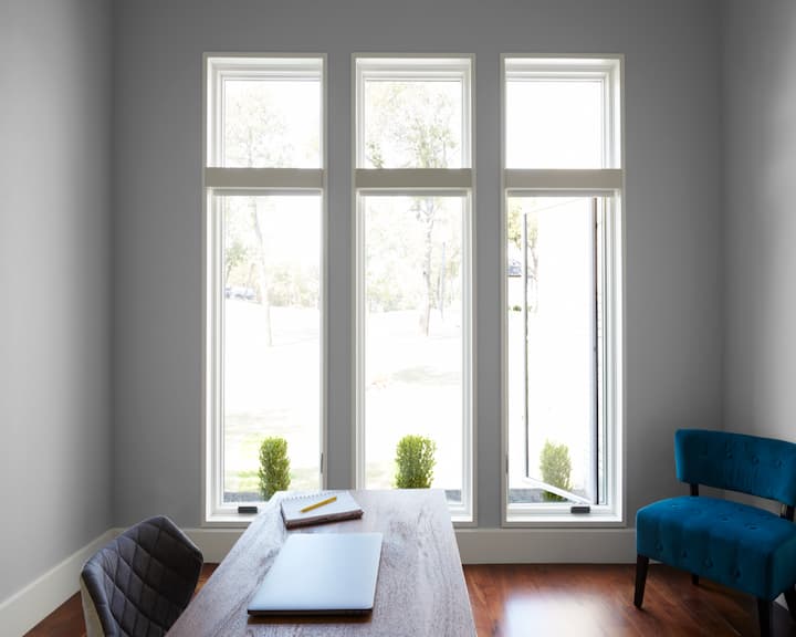 Opened white, contemporary wood casement window in home office