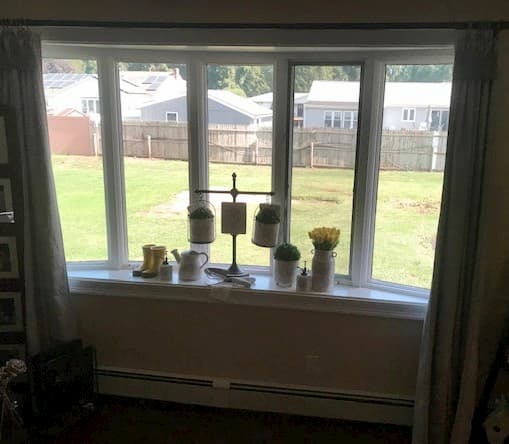 Interior view of white bow window overlooking back yard