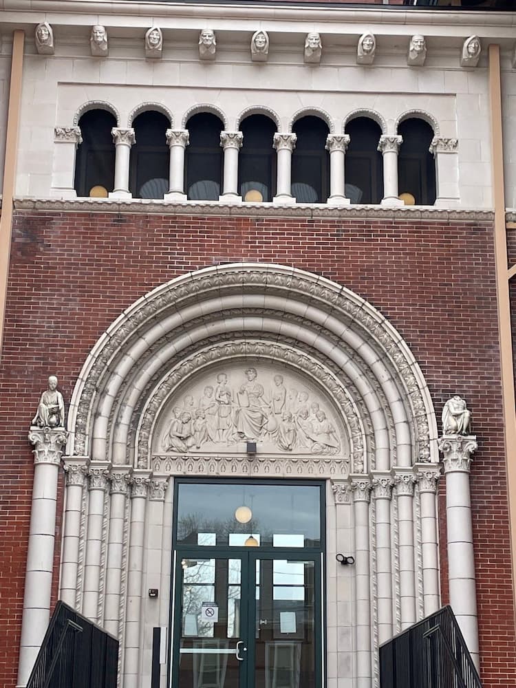 Close up of the tympanum over entry door of historic school building, which are now apartments.