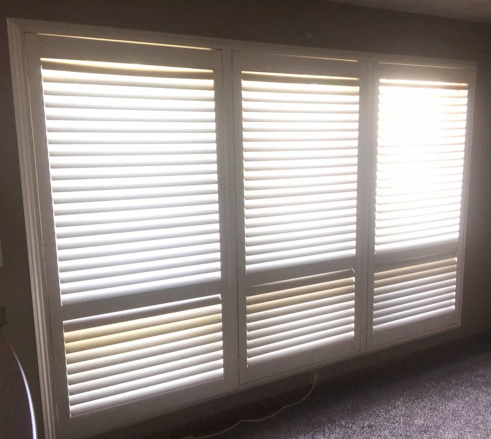 Interior view of three old windows covered with white blinds