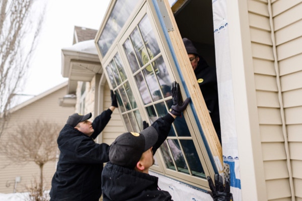 Pella professionals installing large energy-efficient wood windows