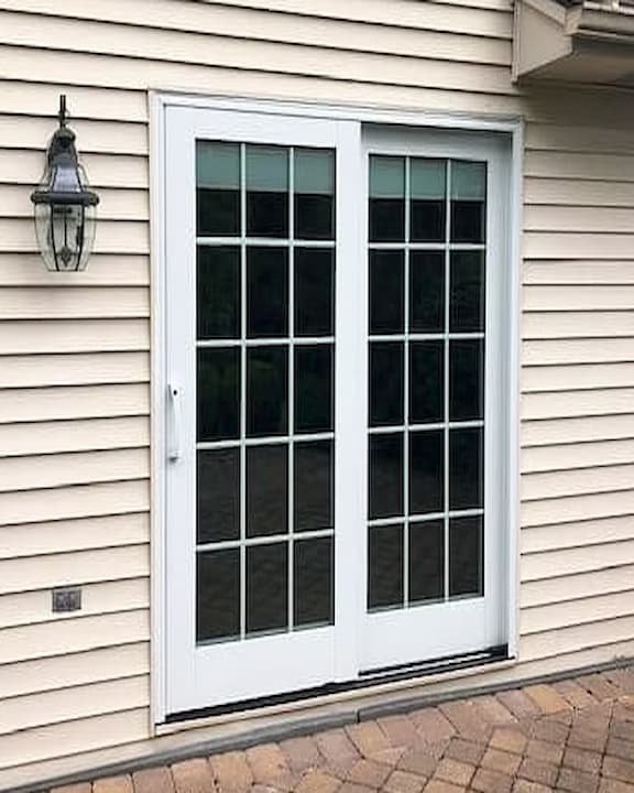 Exterior view of double panel Pella white sliding patio doors with matching grilles