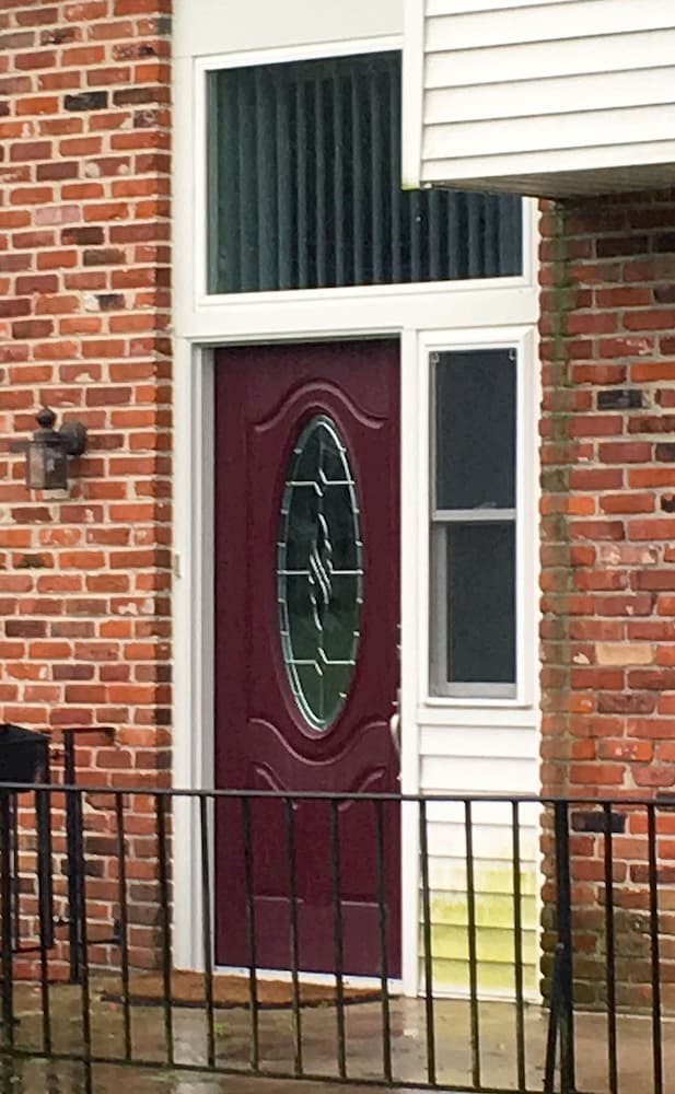Red brick home with maroon fiberglass entry door
