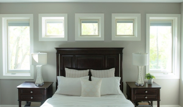 Five triple-glazed windows surrounding bed in master bedroom