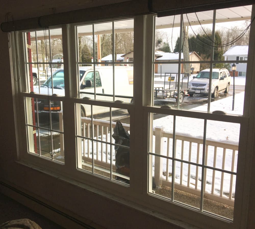 Interior view of three new vinyl double-hung windows looking out over a front porch