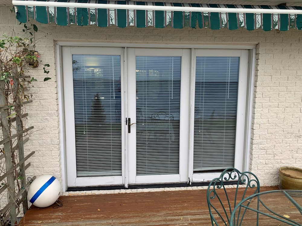 Three-panel hinged French patio door with white trim
