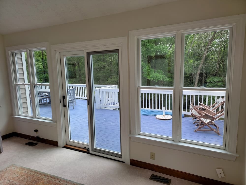 Double-hung windows and sliding patio doors looking out on deck of Powhatan home