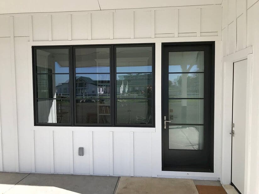 New fiberglass entry door and wood casement windows with contemporary grilles and black finish