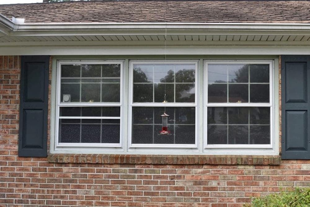 Old double-hung windows on red brick home