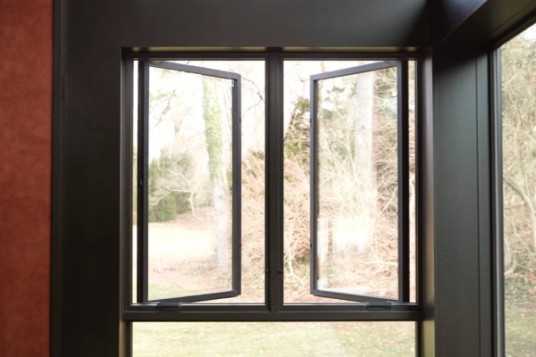 Large casement windows opening to backyard area of home