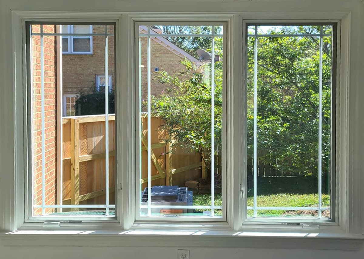 Interior view of three white wood casement windows.