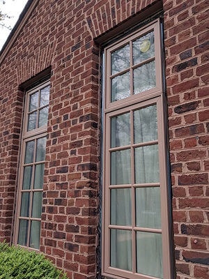 casement wood windows with custom color on brick house