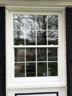 White fiberglass double-hung window with traditional grille pattern