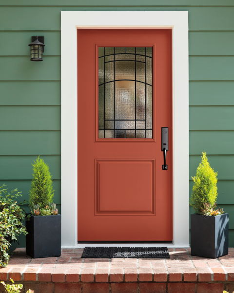 Vibrant accent - this orange front door makes an impact against sage green siding