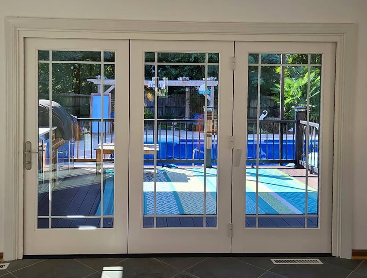 Interior view of white woof bifold patio doors that open onto a patio.