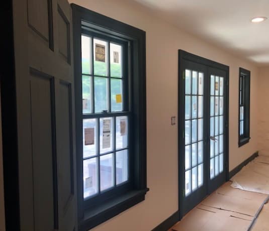 Interior view of wood double-hung windows and French patio doors