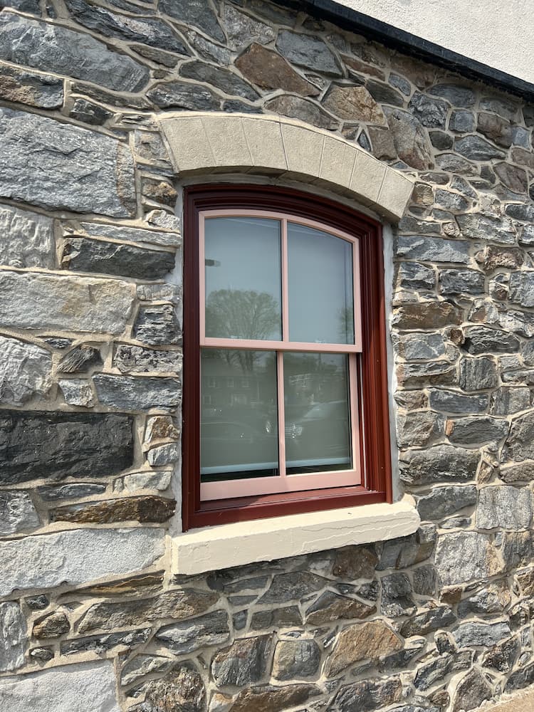 Close up of historic double-hung window replacement with red and pink frames