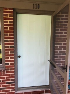 Old white entry door with brown storm door