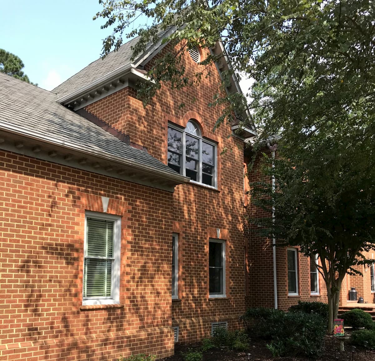 Side view of brick home with new gray wood double-hung windows