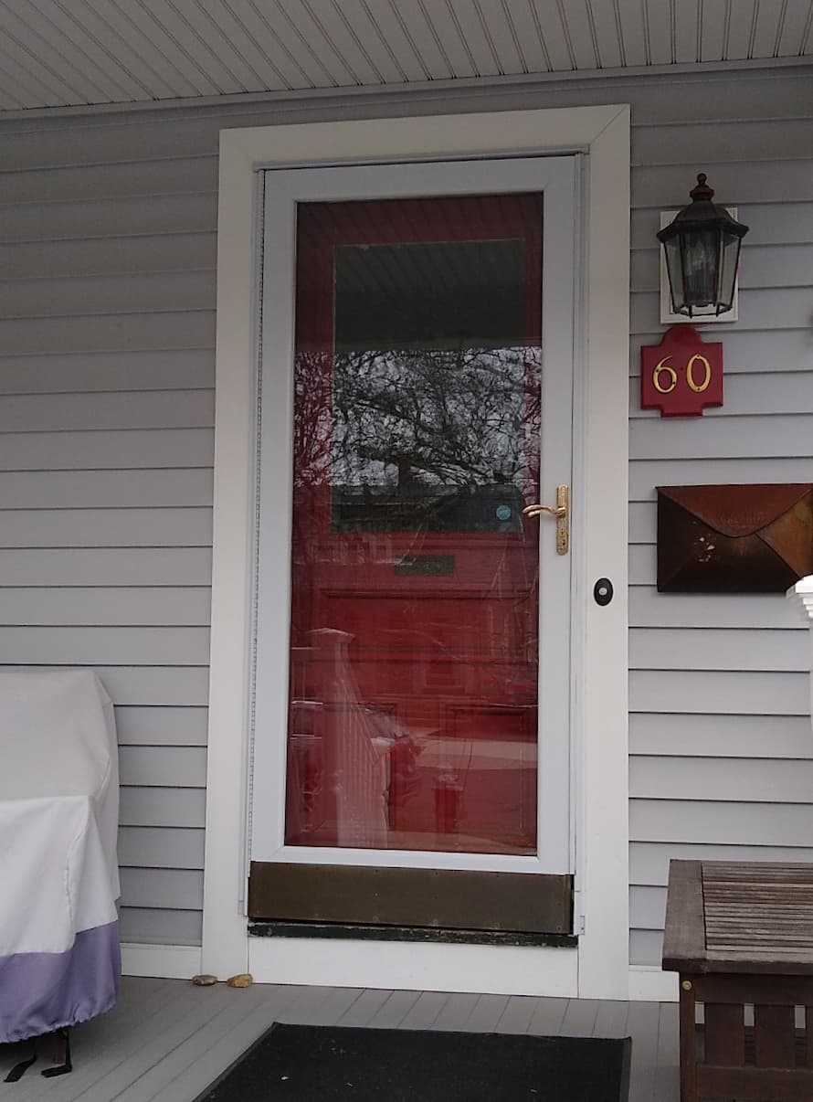Old red entry door with white storm door