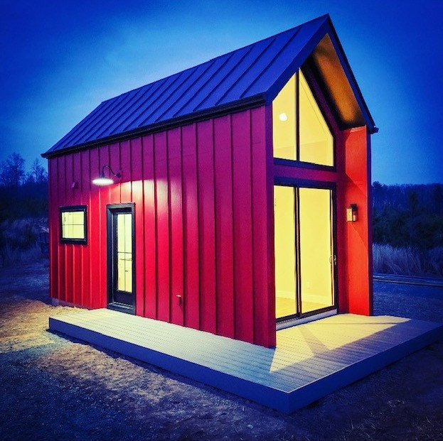 Red wood exterior of tiny home in Charlottesville, VA, with fiberglass windows