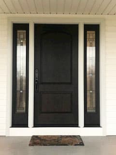 Black front door with sidelights and white trim on white house