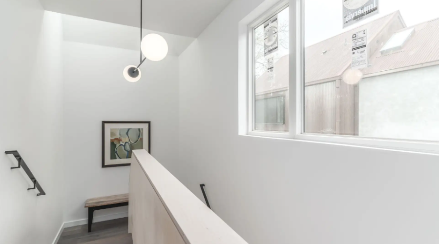 Casement windows add natural light to stairway area of new Austin duplex