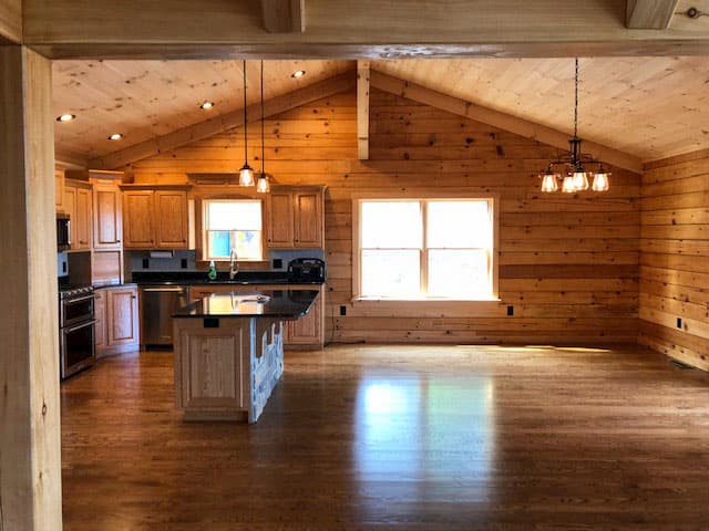 Interior view of log cabin kitchen with new wood windows