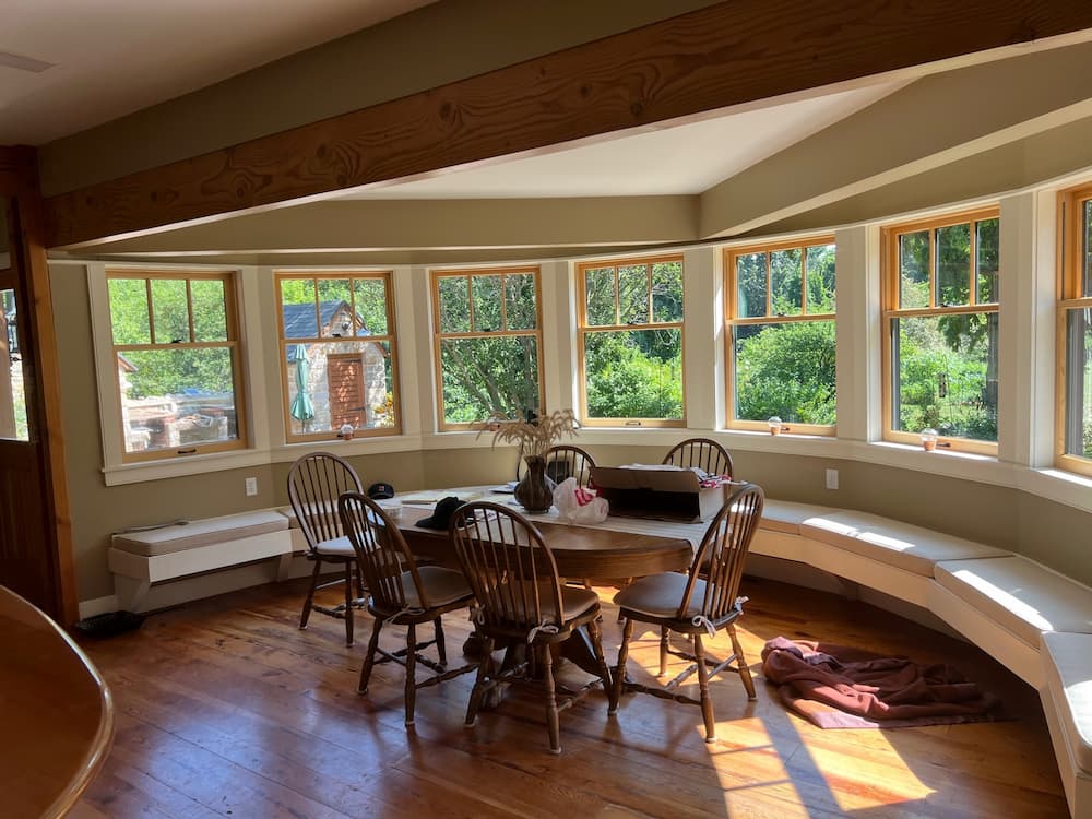 Interior view of dining room natural wood windows overlooking yard