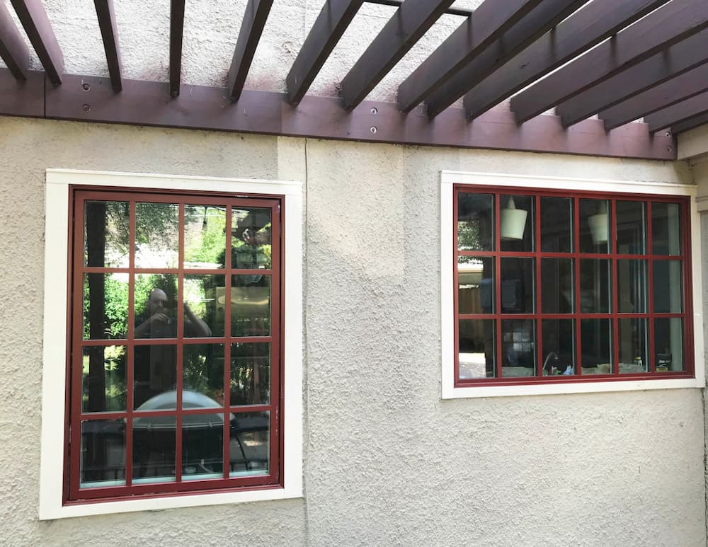 Exterior view of new wood windows with red finish and traditional grille profiles