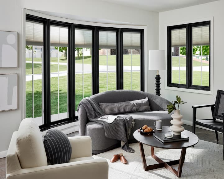 Black window and patio door with blinds between the glass in living room