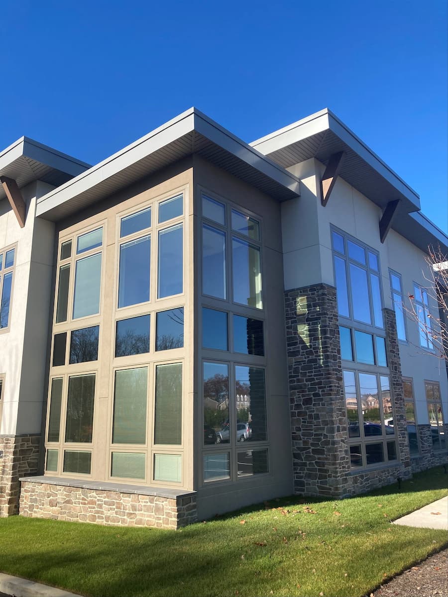 Exterior view of two-story commercial building with aluminum-clad casement windows.
