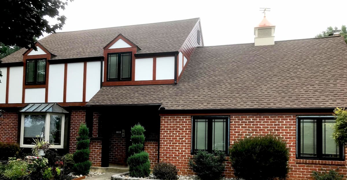 Exterior view of Tudor-style home with black wood casement windows