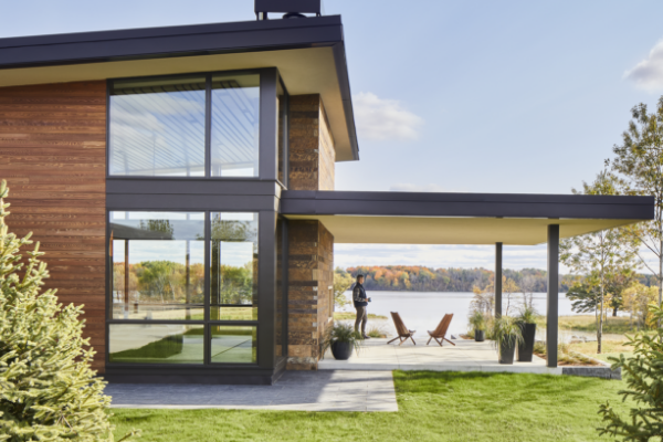 Image shows modern home with black window frames set against wood exterior