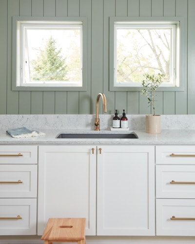 Farmhouse-style awning windows open up above a kitchen sink