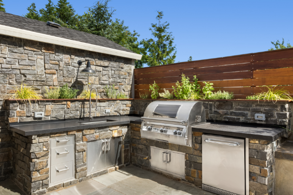 an outdoor kitchen with a beautiful grill island and a functional sink space for easy cleanup