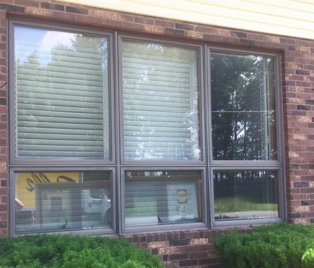 Exterior view of three flat windows on a brick home