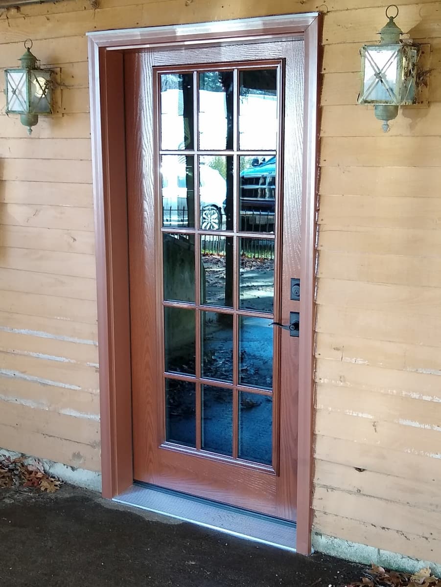 Exterior view of new fiberglass wood-look entry door.