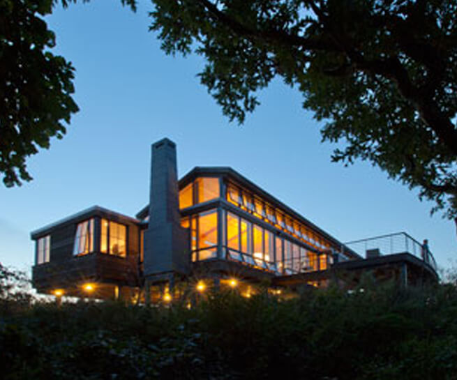 Exterior view of Outermost House with lights on at dusk