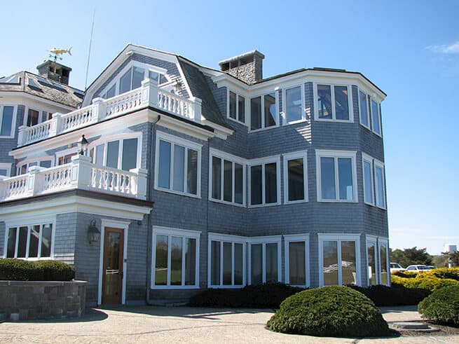 Exterior view of shingle-style home with all-new Pella casement windows