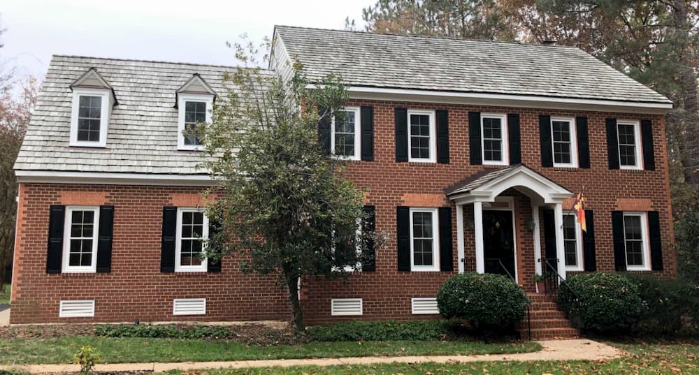 Front exterior view of red brick home with all new white vinyl double-hung windows