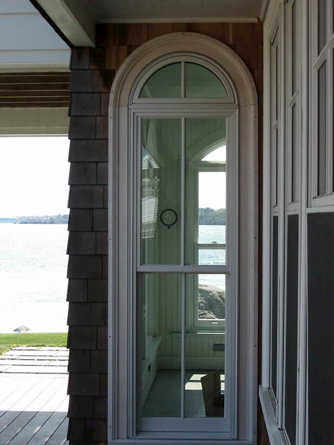 Wood double-hung window with special-shape transom on a shingle-style home