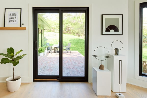 A modern designed home interior in light colors with a dark-framed sliding door
