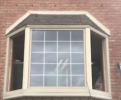 An old bay window on the side of a red brick home