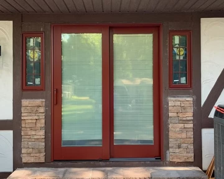 exterior view of red sliding patio door with white blinds