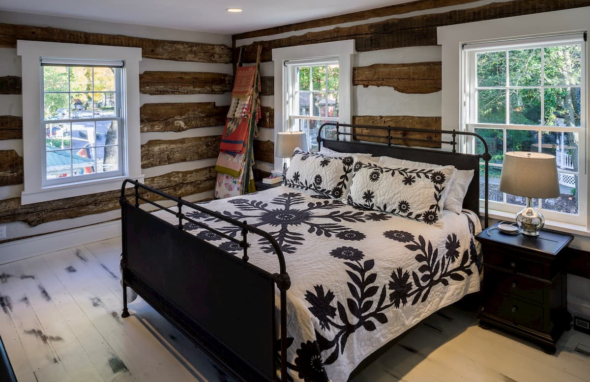Interior view of rustic bedroom with white wood double-hung windows with traditional grille patterns