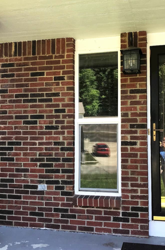 Narrow vinyl double-hung window on a red brick home
